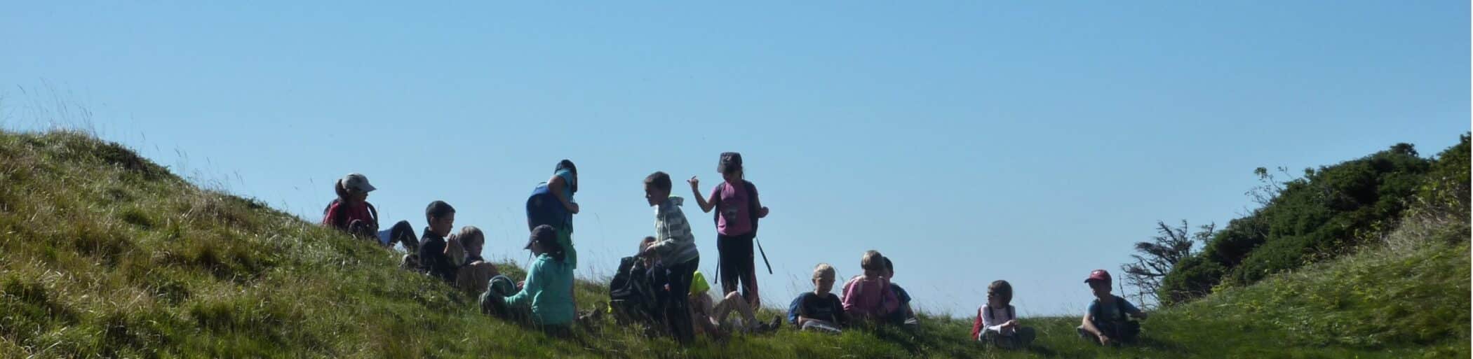 enfants en randonnee en pause en haut du sommet